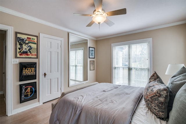 bedroom with baseboards, crown molding, and light wood-style floors