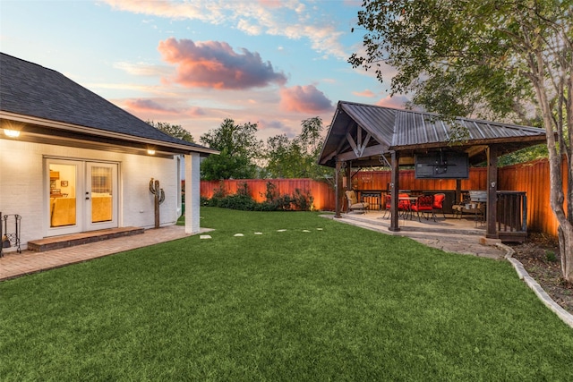 yard at dusk with central AC unit, french doors, fence private yard, and a patio