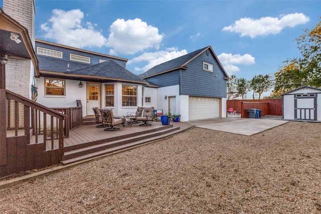 rear view of property with a storage unit, driveway, fence, an outdoor structure, and a garage