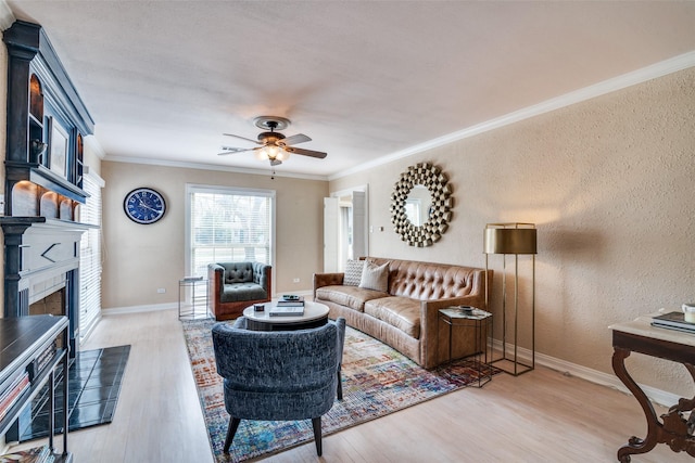 living area featuring baseboards, a ceiling fan, light wood-style floors, and ornamental molding