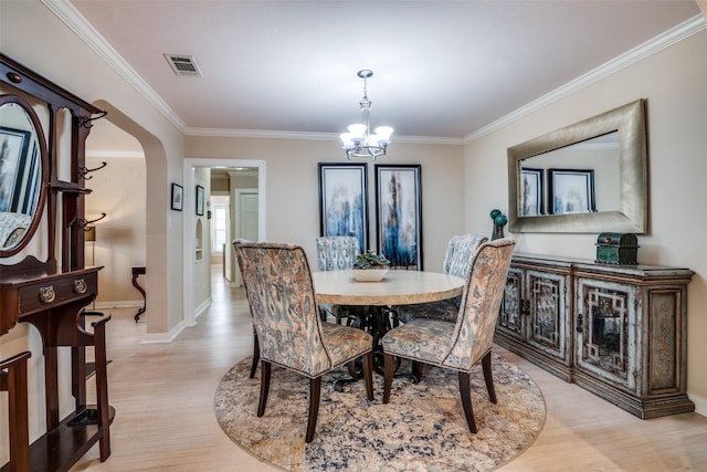 dining space with visible vents, arched walkways, light wood-style floors, crown molding, and a chandelier