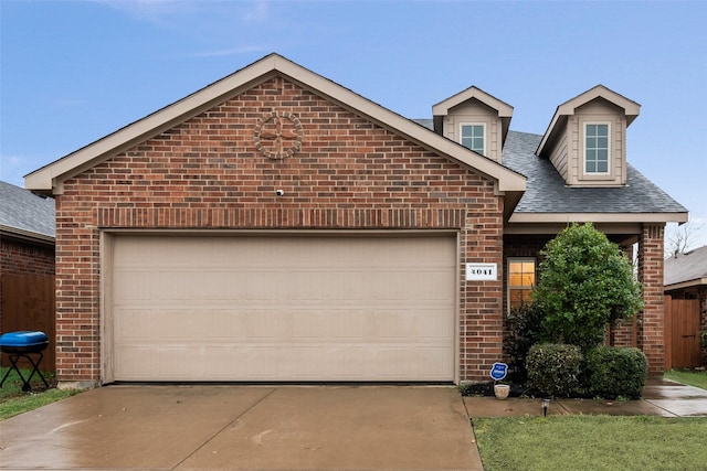 view of front of house with a garage, brick siding, and concrete driveway