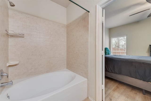 ensuite bathroom featuring ceiling fan, wood finished floors, shower / bathtub combination, and connected bathroom