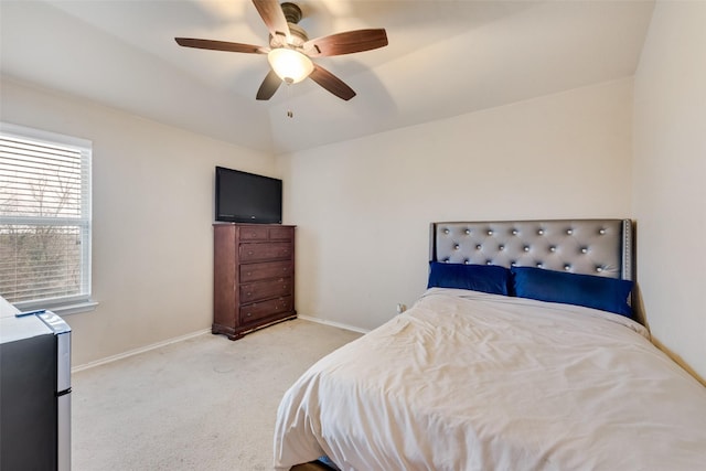 carpeted bedroom featuring lofted ceiling, baseboards, and ceiling fan