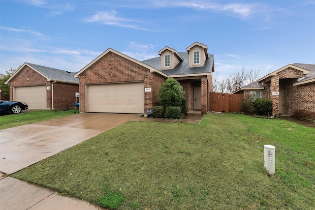 view of front of house with a front lawn, driveway, a shingled roof, a garage, and brick siding