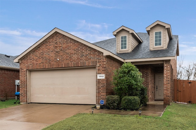 view of front of property with a garage, brick siding, driveway, and roof with shingles