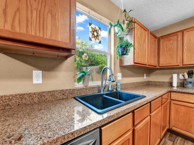 kitchen with a sink, a textured ceiling, and light countertops