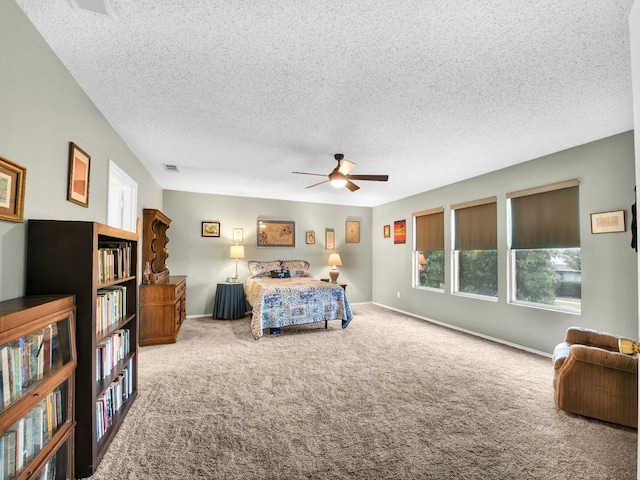 carpeted bedroom featuring baseboards, visible vents, a textured ceiling, and a ceiling fan