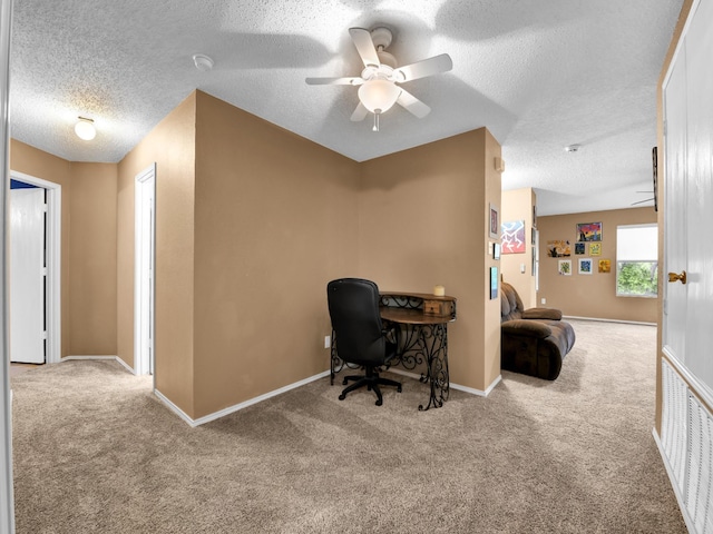 home office featuring baseboards, carpet, a ceiling fan, and a textured ceiling