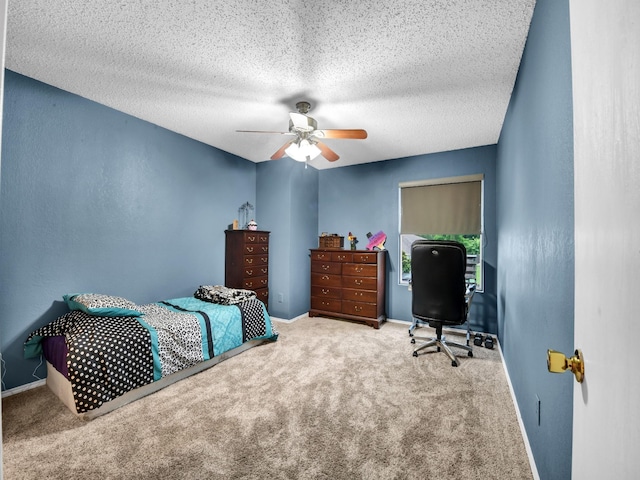 bedroom with ceiling fan, carpet flooring, baseboards, and a textured ceiling