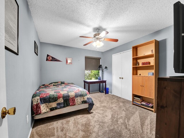 bedroom with a closet, carpet flooring, a textured ceiling, and a ceiling fan