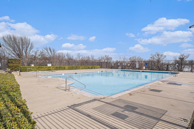 community pool with a patio and fence