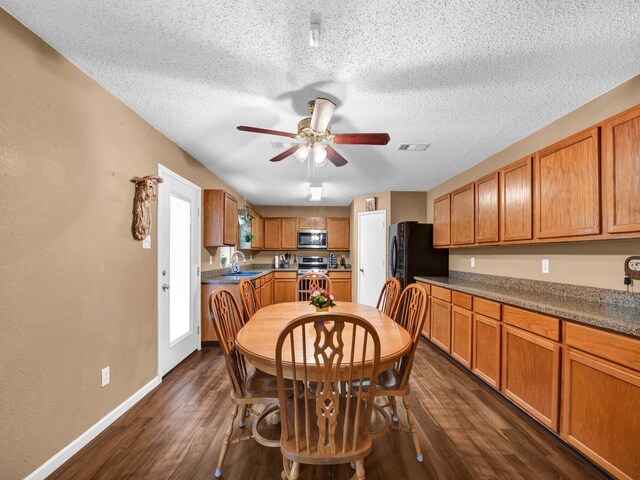 dining room featuring visible vents, ceiling fan, baseboards, a textured ceiling, and dark wood-style flooring