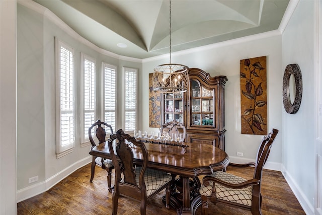 dining space with a notable chandelier, a tray ceiling, dark wood-style floors, crown molding, and baseboards