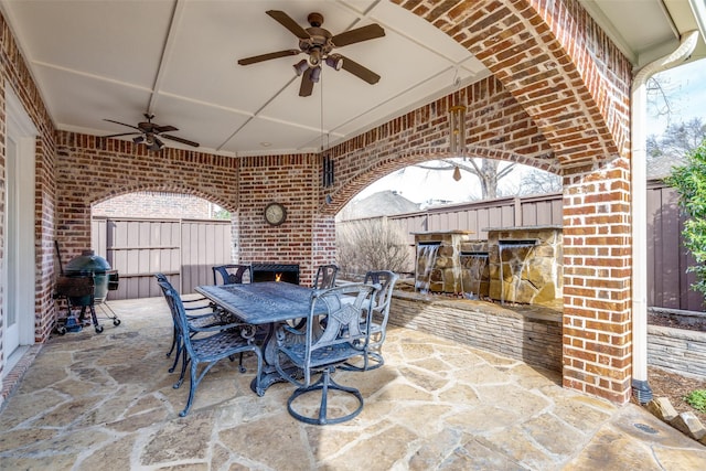 view of patio / terrace featuring a grill, outdoor dining area, a ceiling fan, and fence