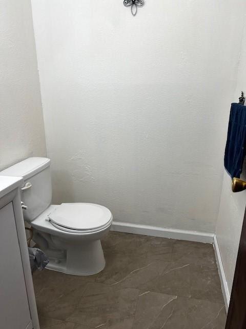 bathroom featuring toilet and baseboards