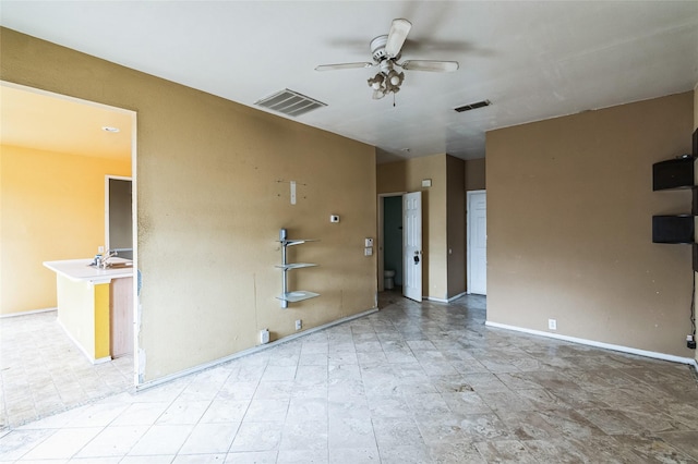 empty room featuring visible vents, baseboards, and a ceiling fan