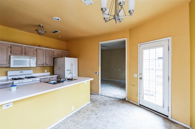 kitchen featuring visible vents, light floors, a wealth of natural light, white appliances, and a sink