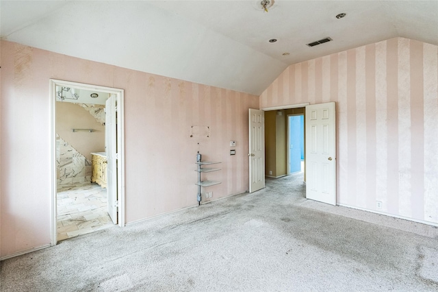 carpeted empty room with visible vents and lofted ceiling