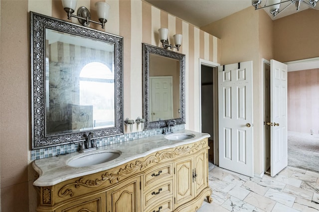 bathroom with a sink, marble finish floor, and double vanity