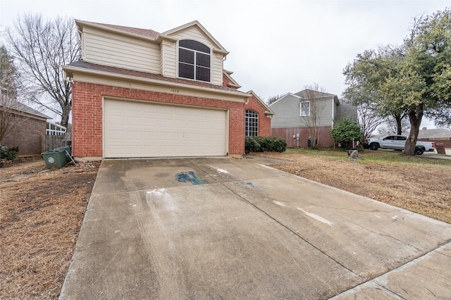 traditional-style house with driveway, brick siding, and an attached garage