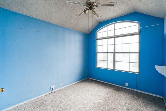 empty room featuring baseboards, lofted ceiling, carpet floors, a textured ceiling, and a ceiling fan