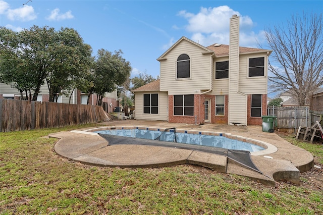 back of house with brick siding, a patio area, a chimney, and a fenced backyard