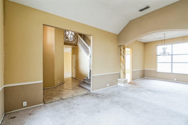 spare room with visible vents, stairs, vaulted ceiling, carpet flooring, and arched walkways