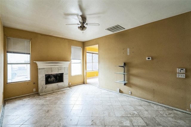 unfurnished living room with visible vents, a ceiling fan, and a fireplace