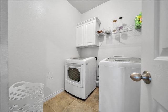 laundry area with cabinet space, baseboards, and washer and clothes dryer