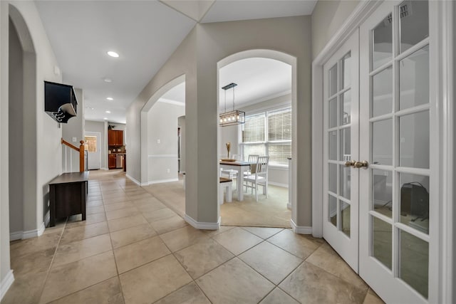 entryway with recessed lighting, stairway, arched walkways, light tile patterned floors, and baseboards