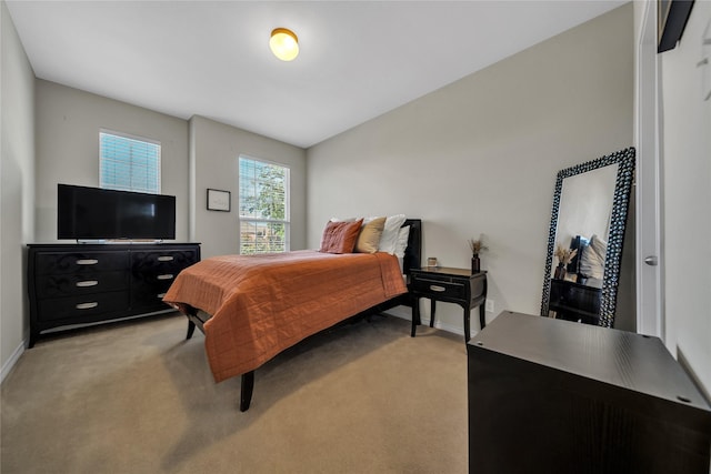 bedroom with baseboards and light colored carpet