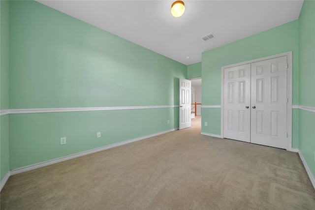 unfurnished bedroom featuring a closet, visible vents, carpet flooring, and baseboards