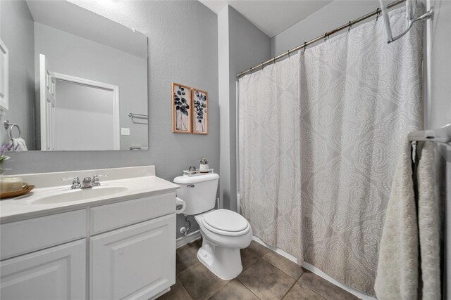 bathroom with tile patterned floors, a shower with curtain, toilet, and vanity