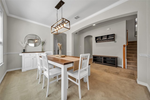 dining area featuring visible vents, stairway, ornamental molding, light carpet, and arched walkways