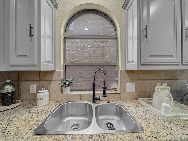 kitchen with tasteful backsplash and a sink