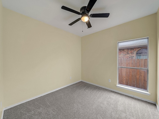 carpeted spare room with baseboards and ceiling fan