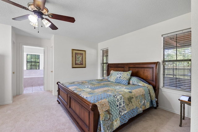 bedroom with a ceiling fan, light colored carpet, baseboards, and a textured ceiling