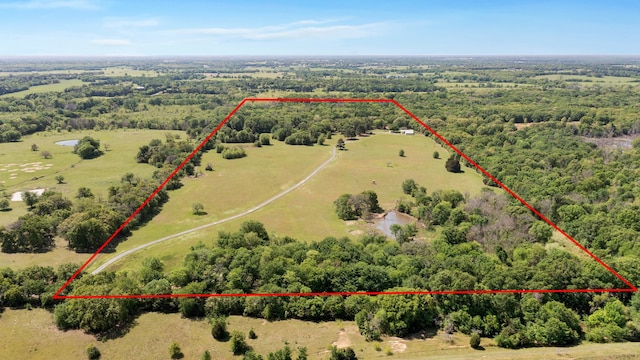 birds eye view of property featuring a rural view and a view of trees