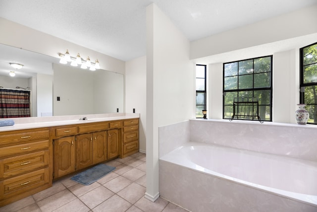 bathroom with vanity, tile patterned floors, a bath, and a textured ceiling