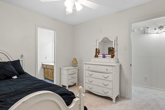 bedroom with baseboards, light colored carpet, ensuite bath, and a ceiling fan