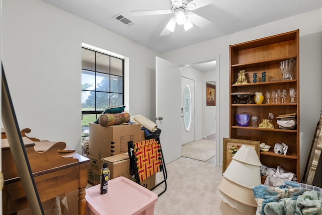 interior space with visible vents, light colored carpet, and a ceiling fan