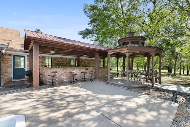 view of property's community featuring a gazebo, a patio area, and outdoor dry bar