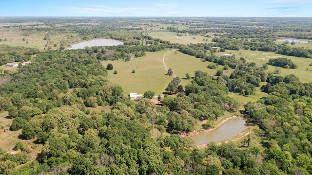 drone / aerial view featuring a water view and a view of trees