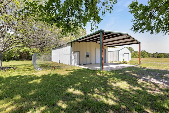 view of pole building with a lawn and fence