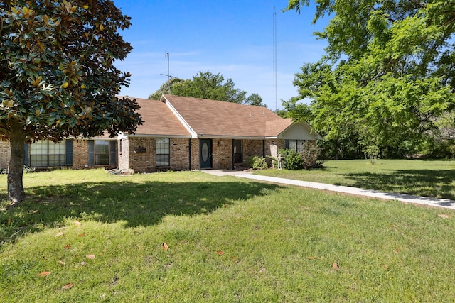 view of front facade with brick siding and a front yard