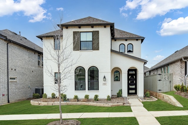 view of front of house featuring a shingled roof, a front lawn, and fence