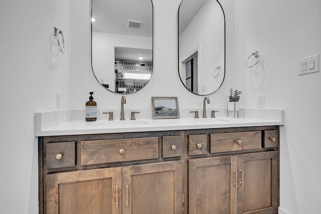 bathroom featuring double vanity, visible vents, and a sink