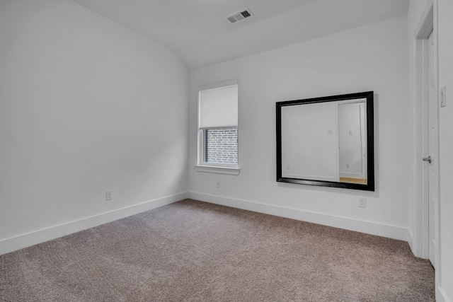 empty room featuring visible vents, baseboards, lofted ceiling, and carpet