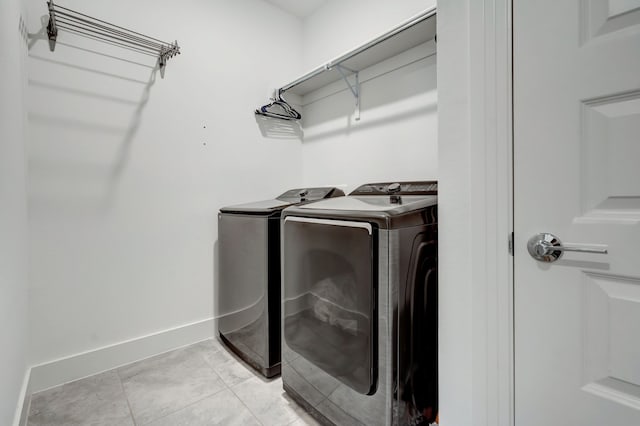 clothes washing area featuring washer and dryer, laundry area, and baseboards